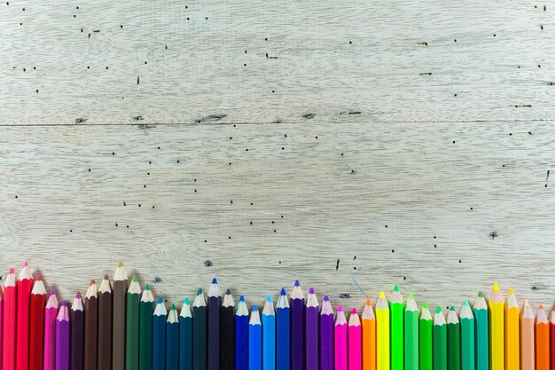 Foto justo por encima de la toma de lápices de colores en la mesa de madera