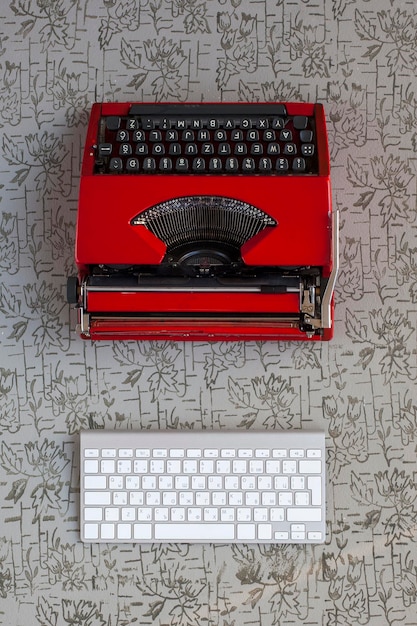 Justo por encima de la toma de la máquina de escribir roja por el teclado de la computadora en la mesa