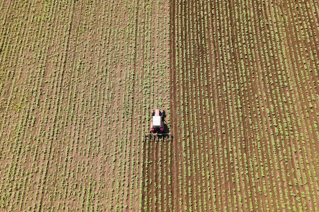 K vista aérea de seguir um trator trabalhando no campo processando o trabalho de campo de terras agrícolas com tecnologia agrícola