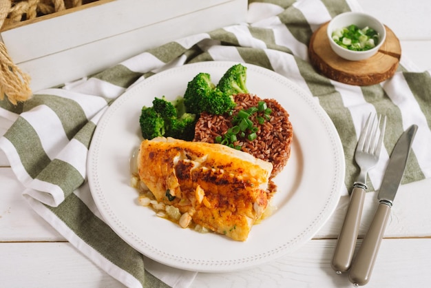 Kabeljaufilet mit braunem Reis und gedämpftem Brokkoli Ein Food-Styling-Display auf dem Teller