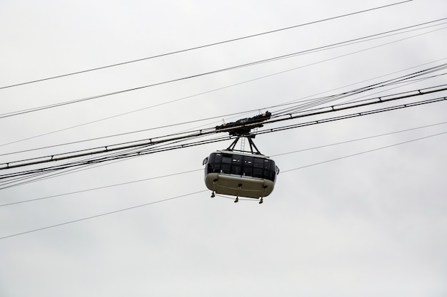 Kabinenseilbahn mit bewölktem Himmel.