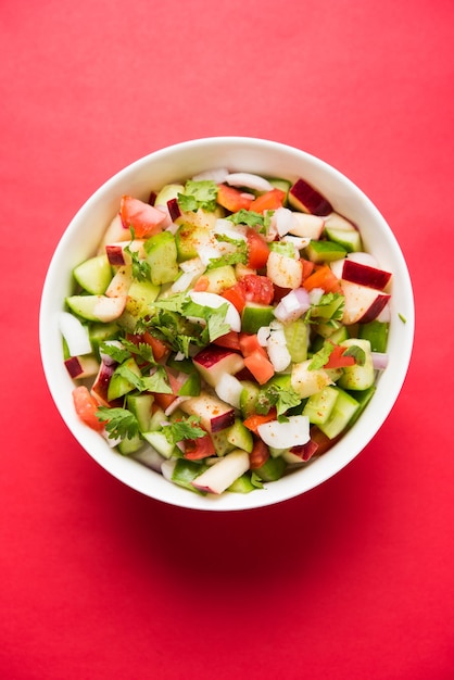 Kachumber ODER indischer grüner Salat, auch bekannt als Koshimbir. Serviert in einer Schüssel über stimmungsvollem Hintergrund. Selektiver Fokus