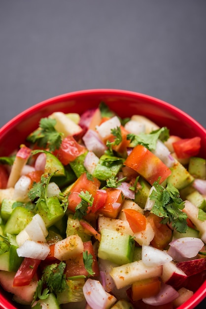 Kachumber ODER indischer grüner Salat, auch bekannt als Koshimbir. Serviert in einer Schüssel über stimmungsvollem Hintergrund. Selektiver Fokus