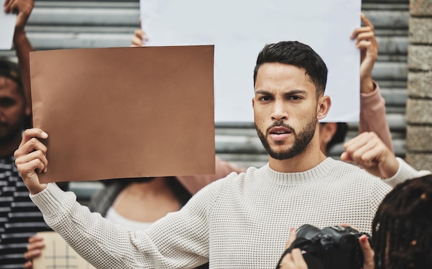 Kämpfe für deine Rechte Abgeschnittenes Porträt eines gutaussehenden jungen Mannes, der ein Schild hält, während er an einer politischen Kundgebung teilnimmt