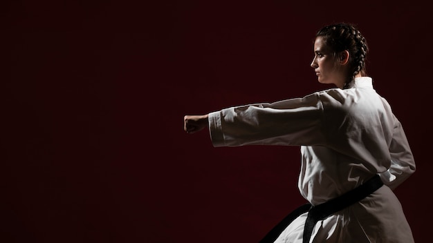 Kämpfende Frau im weißen Karateuniform- und -kopienraum