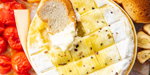 Käse gebackener Brie oder Camembert Tomate Knoblauch und Kräuter gesunde Mahlzeit Snack auf dem Tisch