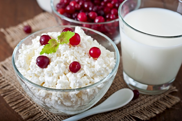 Käse, Milch und Preiselbeeren auf einem Holztisch im rustikalen Stil