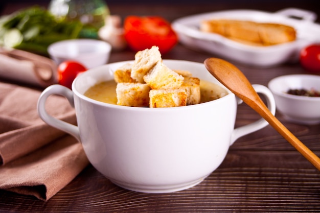 Käse- oder Zwiebelcremesuppe mit Toastbrot in einer weißen Schüssel