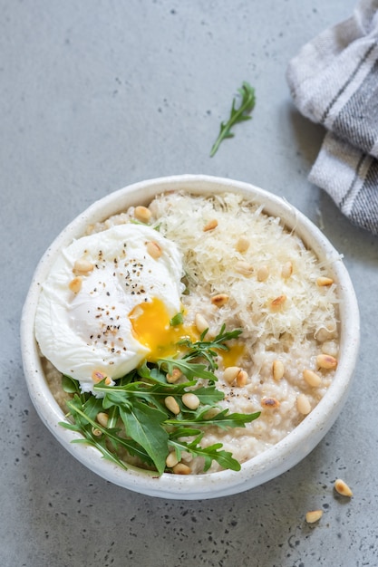 Käse pikantes Haferflocken mit pochiertem Ei und Rucola