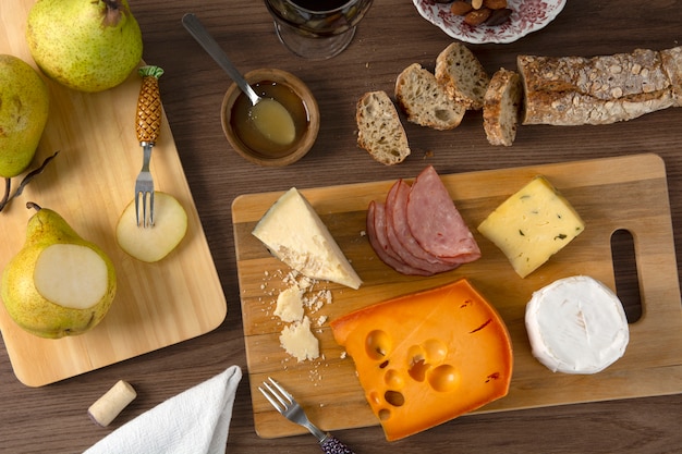 Foto käse, schinken, birnen und brot über hölzernem hintergrund