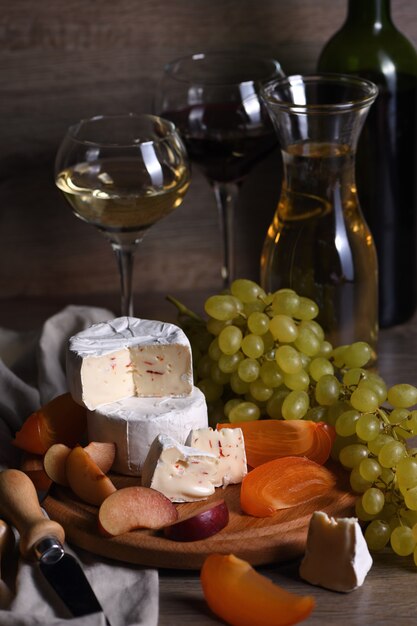 Käsebrie, Camembert mit weißen Trauben, geschnittenen Kakis und Pflaumen, eine großartige Vorspeise für Wein