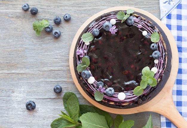 Käsekuchen mit Blaubeergeschmack, gewirbelt mit Blaubeersauce auf einer Kekskrume