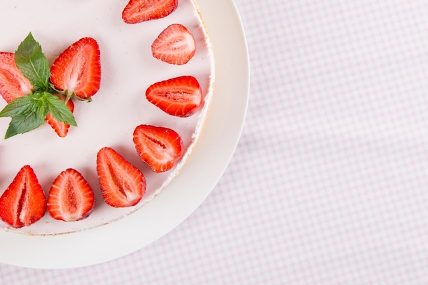 Käsekuchen mit Erdbeeren und Minze auf einem Tisch mit einer leichten Tischdecke Süßes hausgemachtes Frühstück Kopieren Sie Platz