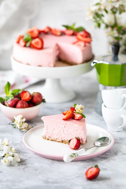 Käsekuchen mit frischen Erdbeeren auf einem weißen Tisch. Selektiver Fokus