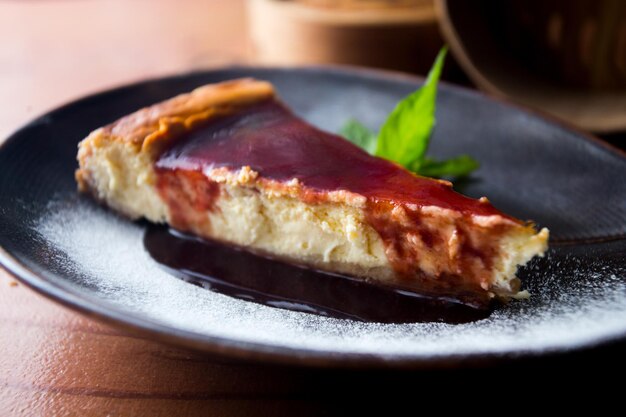 Käsekuchen mit roter Fruchtsauce und frischen Früchten wie Himbeeren, Heidelbeeren oder Erdbeeren.