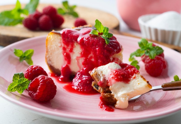 Käsekuchen mit roter Fruchtsauce und frischen Früchten wie Himbeeren, Heidelbeeren oder Erdbeeren.