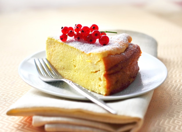 Käsekuchen verziert mit roter Johannisbeere