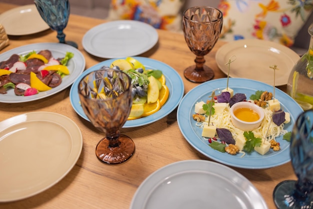 Käseplatte mit Käse Dorblu, Parmesan, Brie, Camembert und Roquefort beim Servieren auf dem Tisch aus einer alten Baumnahaufnahme.