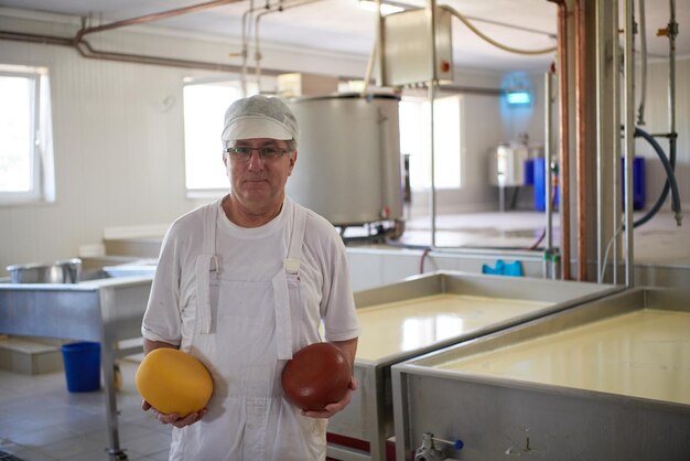 Käseproduktion männlicher Käsermitarbeiter, der in der Fabrik arbeitet