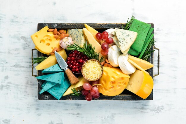 Käseset mit snacks in einer holzkiste auf weißem holzhintergrund freier kopierplatz