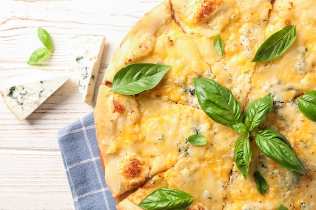 Foto käsestücke und pizza mit basilikum auf weißem hintergrund