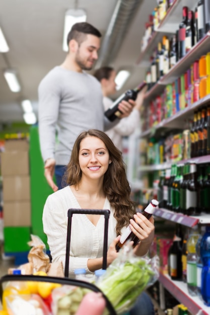 Käufer, die Flasche Wein am Spirituosenladen wählen