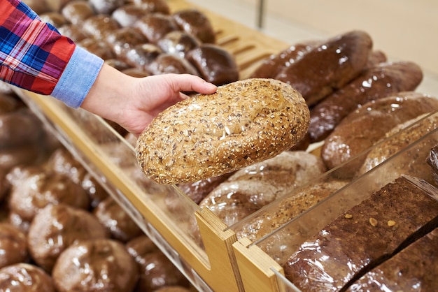 Käufer mit einem Brot im Laden