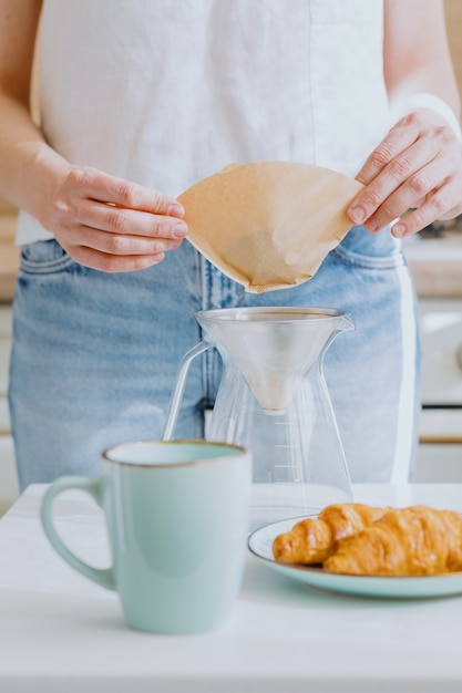 Kaffee am Morgen Europäische Frau brüht Kaffee und trinkt es Croissants und Kaffee zum Frühstück