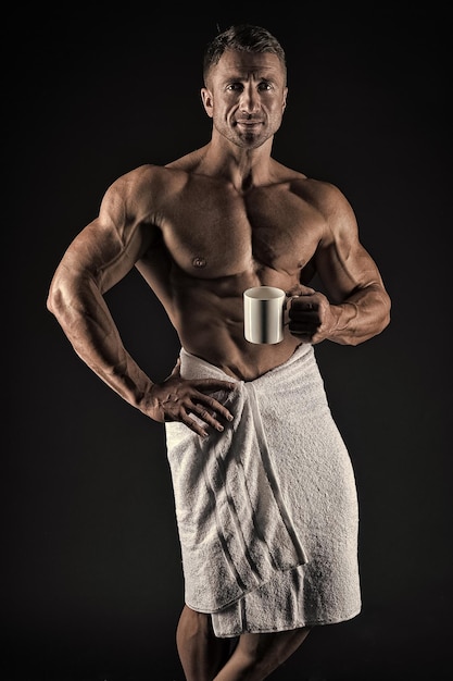 Kaffee am Morgen Sexy Sportler wischt Körpertuch nach der Dusche ab Mann muskulös fit nackter Oberkörper Athlet mit Sixpack und Bauchmuskeln Sport und Fitness Körperhygienekonzept Bodybuilder nackter Körper