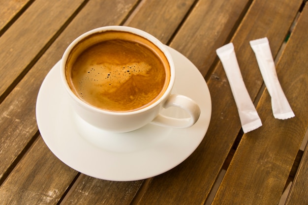 Kaffee Americano in der weißen Tasse auf dem Holztisch
