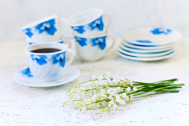 Kaffee auf weißem Hintergrund und Blumen. Maiglöckchen. Frühling. Morgen. 8. März. Frauentag