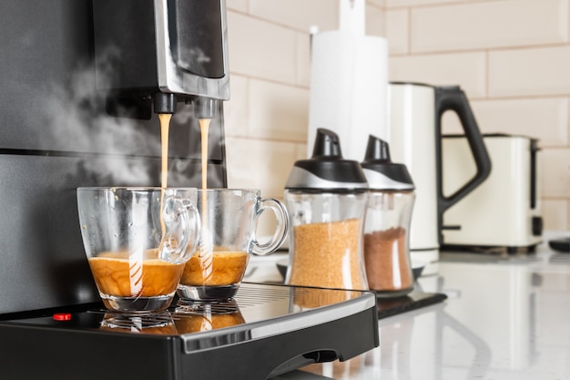 Kaffee aus der Kaffeemaschine wird in Glasbecher gegossen