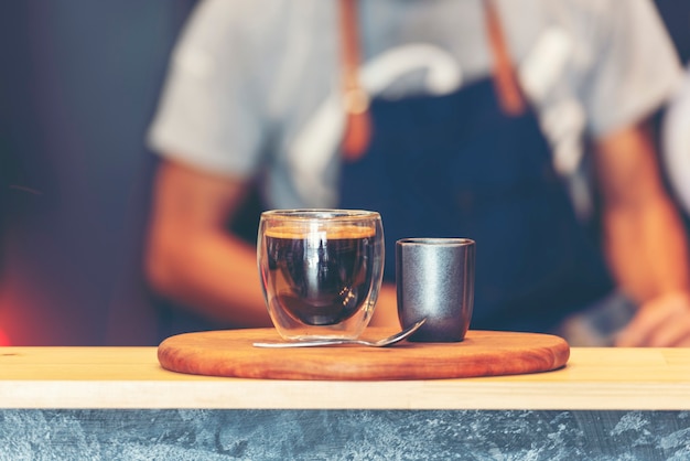 Kaffee-Barista macht Espresso aus der heißen Tasse der Kaffeemaschine