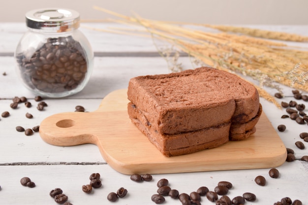 Kaffee-Brot und Kaffeebohne zum Frühstück auf hölzernem Hintergrund