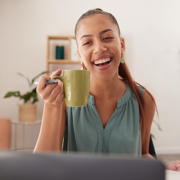 Kaffee glücklich und Frau bei einem Videoanruf mit einem Laptop für das Geschäft, das E-Mails liest und in einem Haus arbeitet Internetkommunikation und Remote-Unternehmerin mit einem Lächeln und Tee mit einem PC für den Job