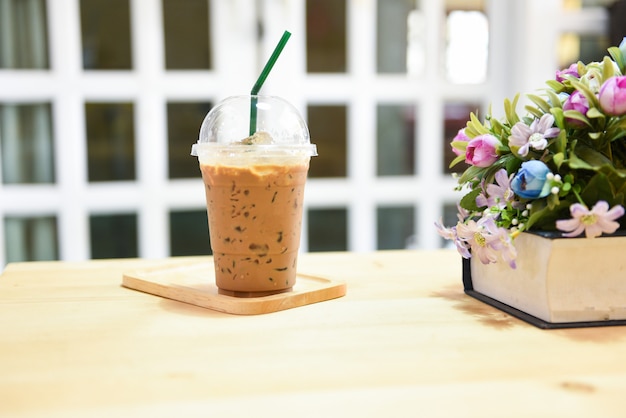 Kaffee im Plastikbecher auf Holztisch