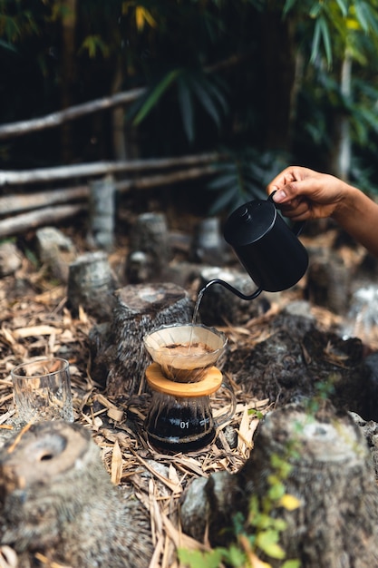 Kaffee im Wald tropfen, heißes Wasser in Kaffee gießen