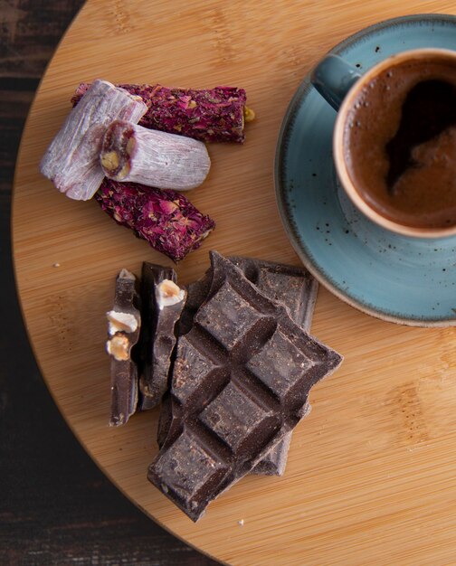 Kaffee in blauer Tasse auf Holztischschokolade und türkischem Bonbon