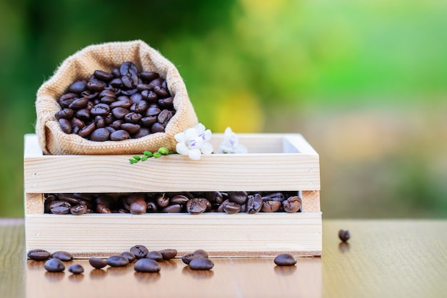 Foto kaffee in der holzkiste mit grünem unscharfem hintergrund