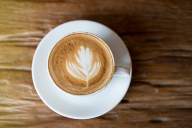 Kaffee in der weißen Schale auf Holztisch