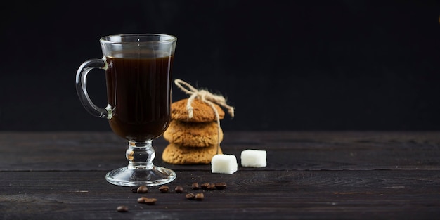 Kaffee in einem klaren Glas und Kekse auf dem Tisch