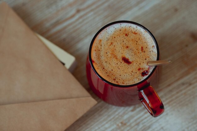 Kaffee in einer Glastasse und Morgenpost auf einem Holztisch