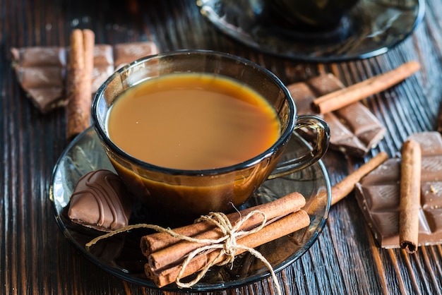 Kaffee in einer Glastasse und Zimt auf dem Tisch