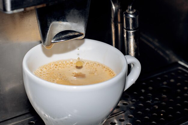 Kaffee in einer Kaffeemaschine mit weißer Tasse zubereiten