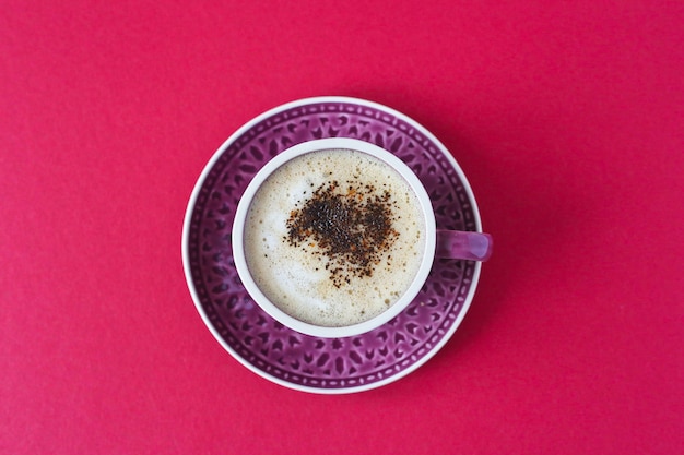 Kaffee in einer lila Tasse auf dem roten Tisch