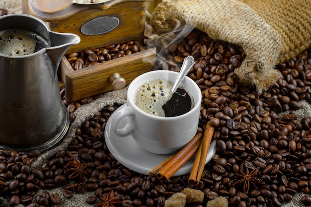 Kaffee in einer Tasse auf einem Hintergrund von Kaffeebohnen, auf einem alten Hintergrund