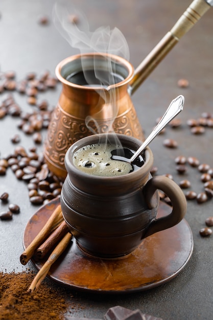 Kaffee in einer Tasse auf einem Hintergrund von Kaffeebohnen, auf einem alten Hintergrund