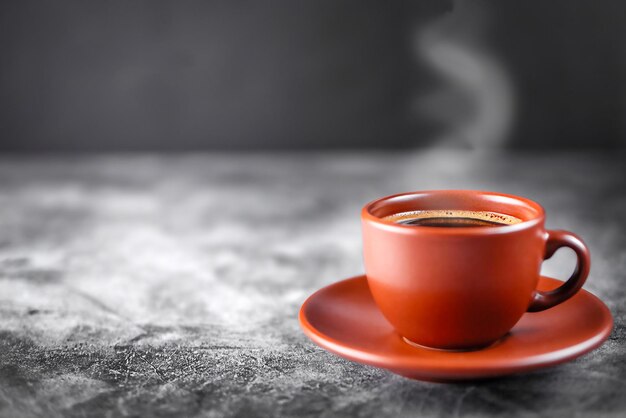 Kaffee in einer Tasse auf einem Tisch in einem Café auf einem grauen Hintergrund