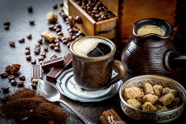 Kaffee in einer Tasse und Untertasse auf einem schwarzen Hintergrund