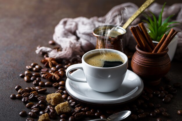 Kaffee in einer Tasse und Untertasse auf einem schwarzen Hintergrund